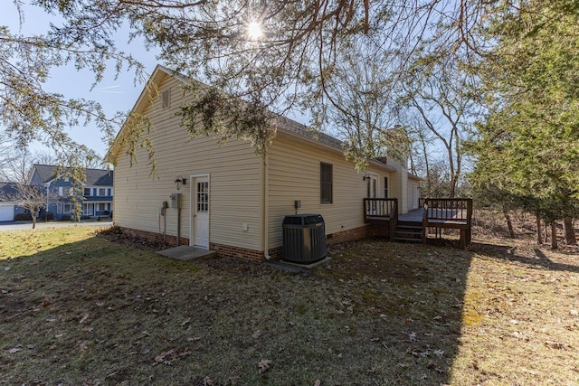 rear view of house with a deck, a lawn, and central AC