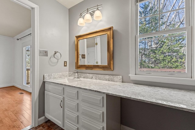 bathroom featuring vanity, visible vents, wood finished floors, and baseboards