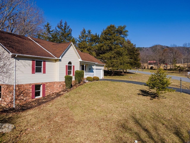 view of property exterior with aphalt driveway, an attached garage, and a yard