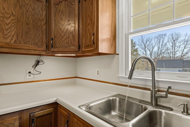 kitchen with brown cabinets, light countertops, and a sink