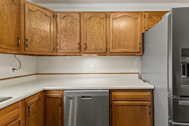 kitchen featuring brown cabinetry, appliances with stainless steel finishes, and light countertops