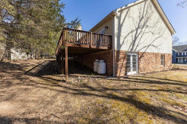 view of side of home featuring a deck and brick siding