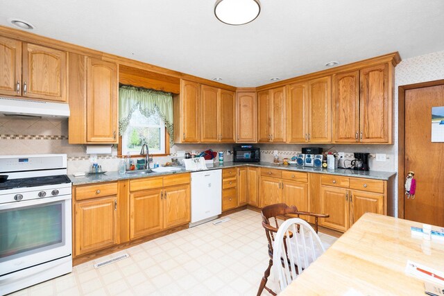 kitchen featuring white appliances, sink, and backsplash