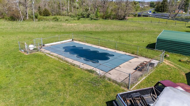 view of pool with a lawn