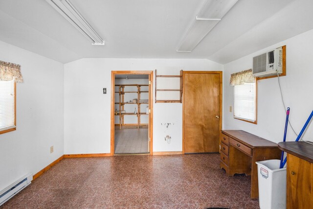 interior space with lofted ceiling, a baseboard radiator, and a wall mounted AC