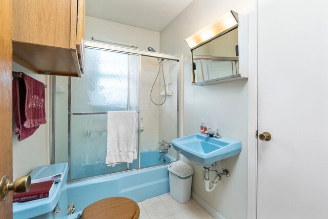 bathroom with shower / bath combination with glass door and toilet