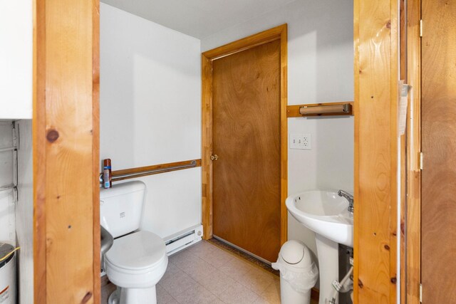 bathroom with baseboard heating and toilet