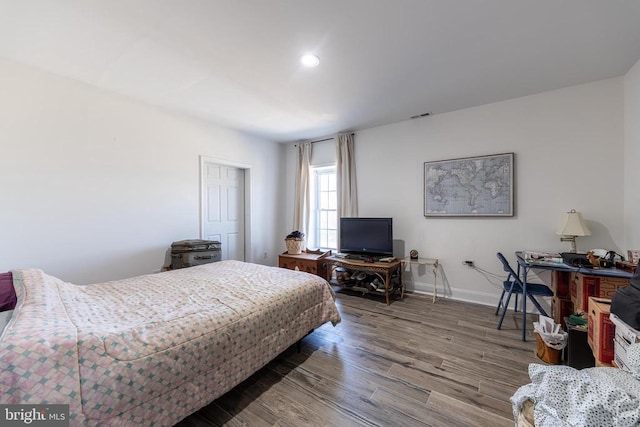 bedroom featuring baseboards, wood finished floors, and recessed lighting