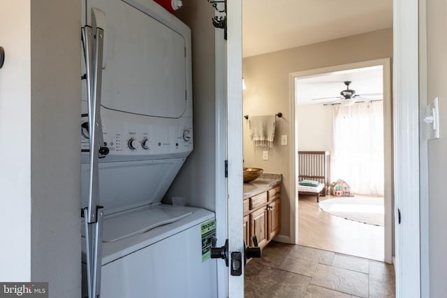 washroom featuring stacked washer and dryer, laundry area, and ceiling fan