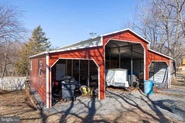 view of pole building with fence and a carport