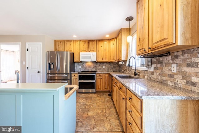 kitchen with decorative backsplash, stone finish floor, appliances with stainless steel finishes, decorative light fixtures, and a sink