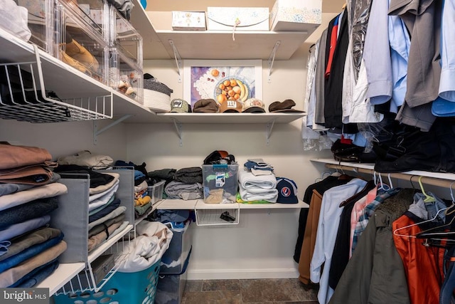 spacious closet featuring stone finish flooring