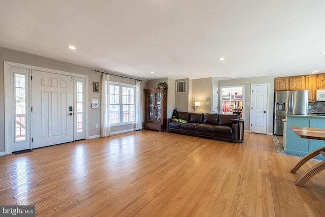 unfurnished living room featuring recessed lighting, baseboards, visible vents, and light wood finished floors