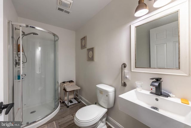 bathroom with visible vents, a shower stall, toilet, and wood finished floors