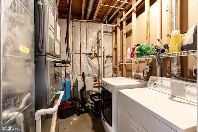 laundry area featuring laundry area, washing machine and clothes dryer, and heating unit