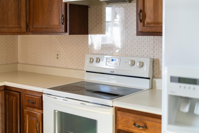 kitchen with exhaust hood and white range with electric stovetop