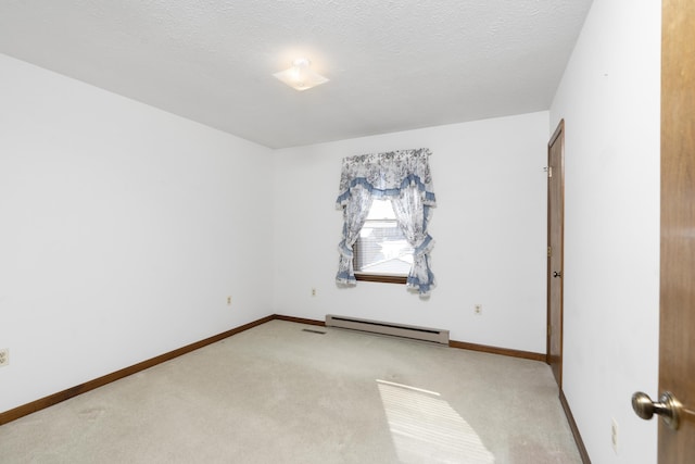 carpeted empty room with a baseboard heating unit and a textured ceiling