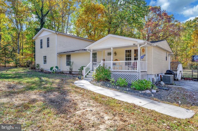 view of front of property with a porch, a front yard, and central AC unit