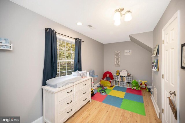 game room featuring light wood finished floors, visible vents, and baseboards