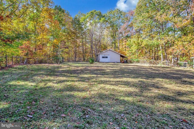 view of yard featuring a fenced backyard, a view of trees, and an outbuilding