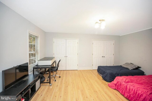 bedroom with multiple closets and hardwood / wood-style floors