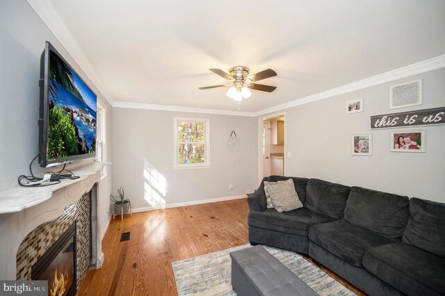 living room featuring ornamental molding, ceiling fan, and light hardwood / wood-style flooring