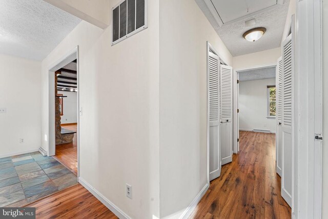 hall featuring dark hardwood / wood-style floors and a textured ceiling