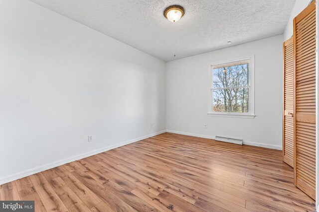 unfurnished bedroom featuring a closet, a textured ceiling, and light wood-type flooring