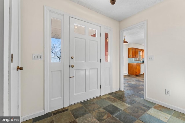 foyer entrance with a textured ceiling