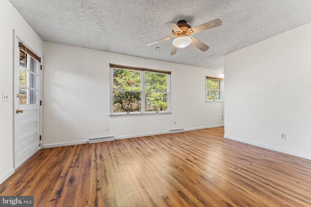 unfurnished room with hardwood / wood-style floors, a textured ceiling, and ceiling fan