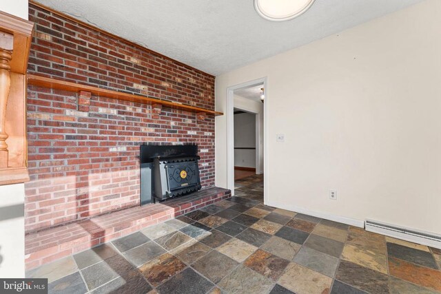 unfurnished living room with a baseboard radiator, a textured ceiling, and a wood stove