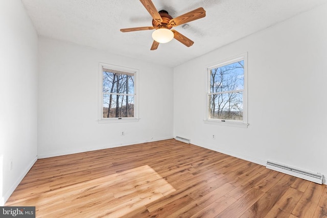 unfurnished room with ceiling fan, a textured ceiling, baseboard heating, and light hardwood / wood-style flooring