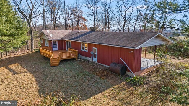 exterior space with a wooden deck and a lawn