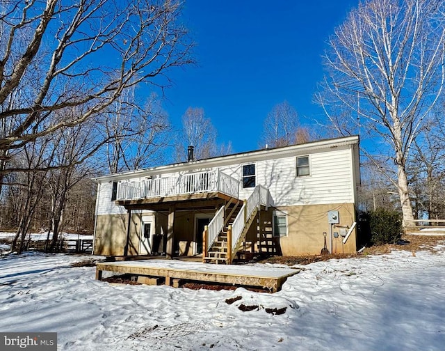 snow covered house with a deck