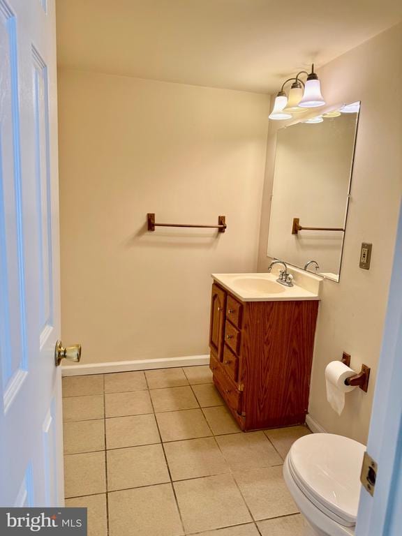 bathroom with tile patterned flooring, vanity, and toilet