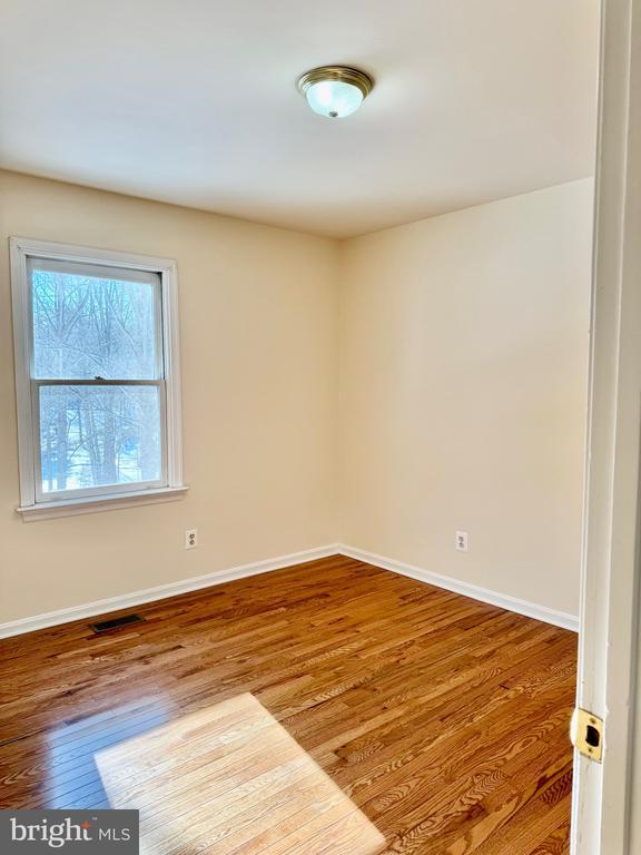 unfurnished room with hardwood / wood-style floors