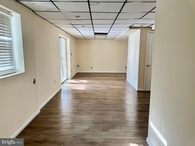 spare room featuring a drop ceiling and hardwood / wood-style flooring