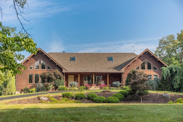 log-style house with a porch and a front yard