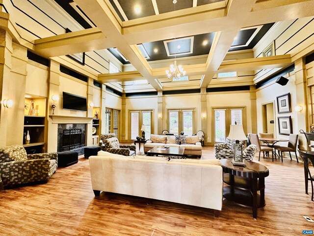 living room featuring hardwood / wood-style floors, a premium fireplace, french doors, and a towering ceiling