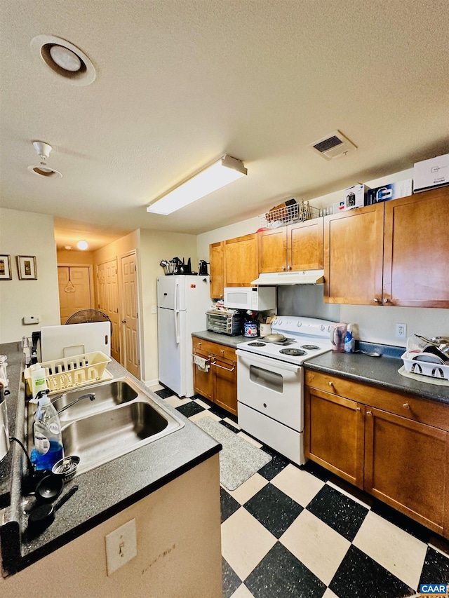 kitchen featuring sink, white appliances, and a textured ceiling