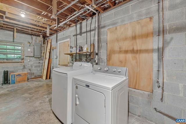 clothes washing area featuring electric panel, laundry area, and washer and clothes dryer