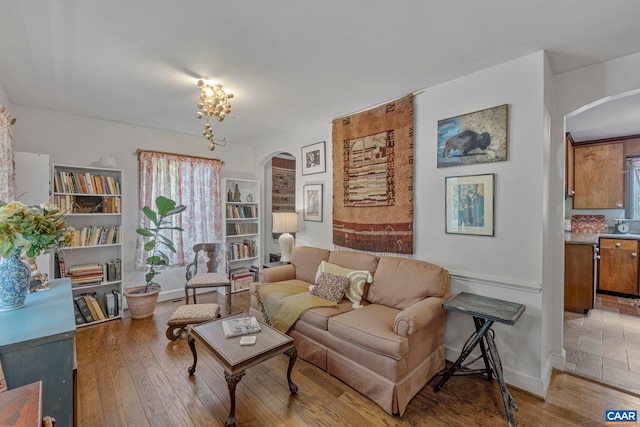 living area featuring arched walkways and light wood-style floors