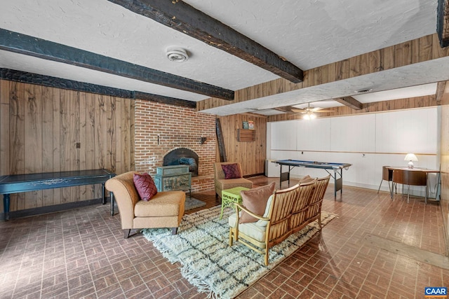 interior space with wooden walls, a textured ceiling, brick patterned floor, and beam ceiling