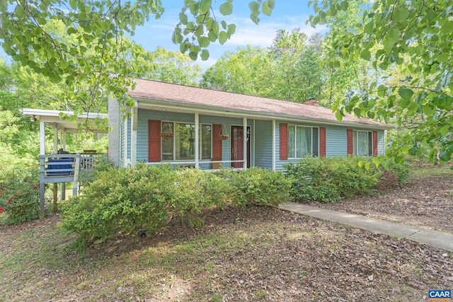 single story home with covered porch and a chimney