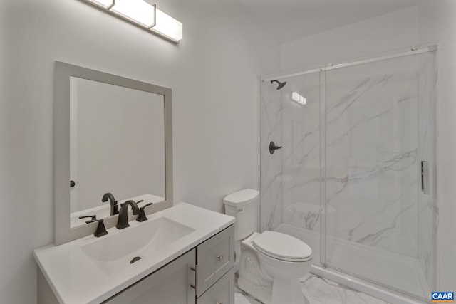 bathroom featuring vanity, a shower with shower door, and toilet