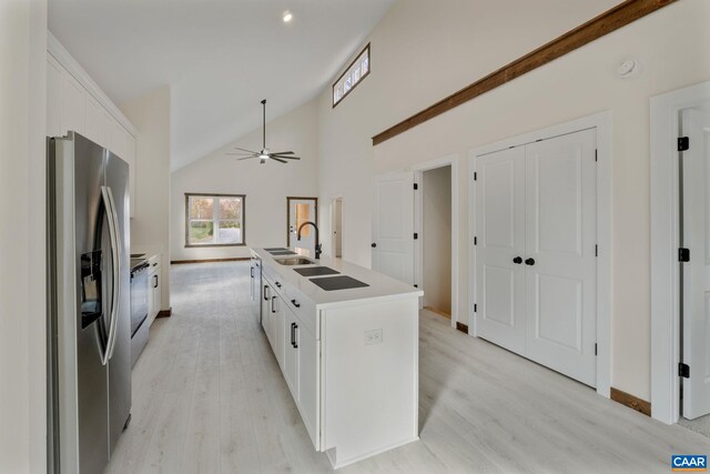 kitchen featuring an island with sink, appliances with stainless steel finishes, white cabinets, and light hardwood / wood-style flooring