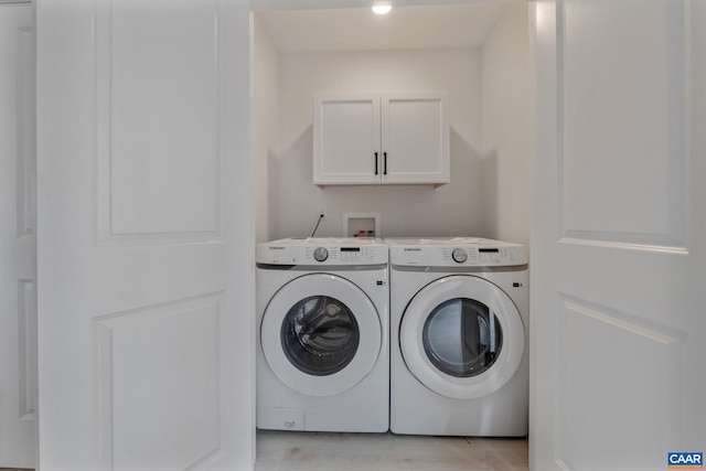 washroom with cabinets and washing machine and clothes dryer