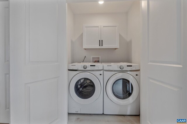 washroom with cabinets and washing machine and clothes dryer