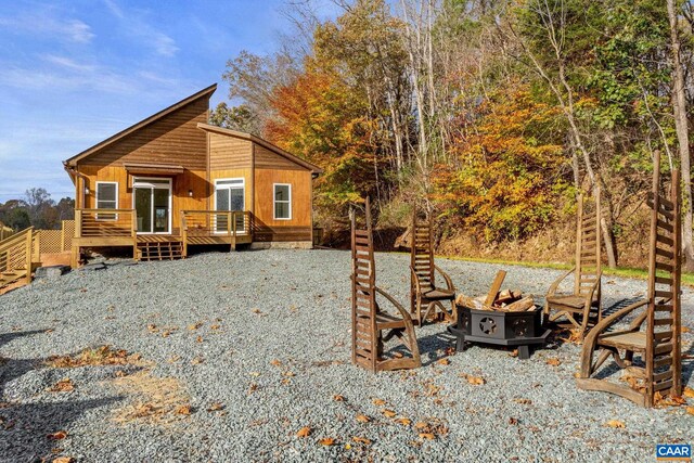 exterior space featuring a deck and an outdoor fire pit