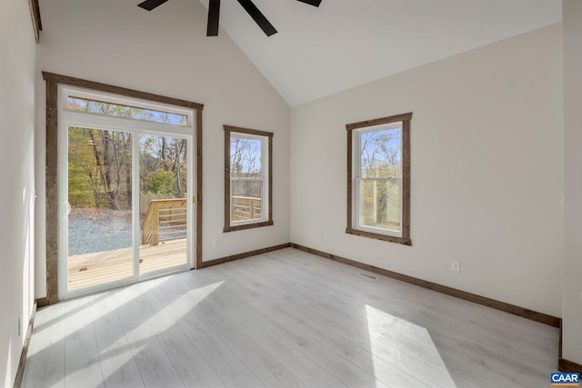 unfurnished room with plenty of natural light, high vaulted ceiling, light hardwood / wood-style floors, and ceiling fan